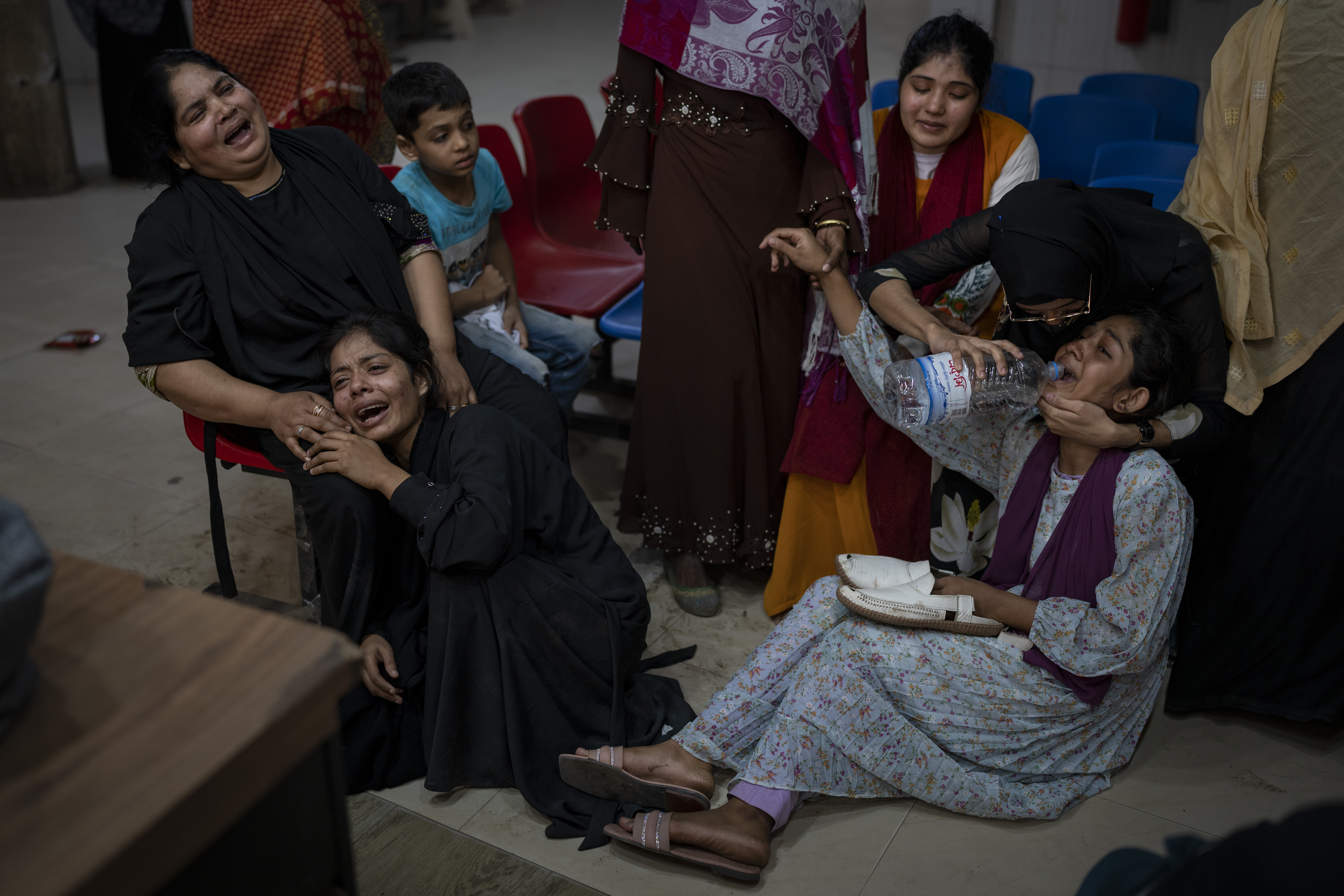 Daughter, right, holds the sandals of slain Mohammad Zillur, as family members wail at a hospital in Munshiganj, outside Dhaka, Bangladesh, Sunday, Jan. 7, 2024. Zillur, a supporter of a candidate from the ruling Awami League was stabbed to death on Sunday as Bangladesh voted in a parliamentary election boycotted by the main opposition party. (AP Photo/Altaf Qadri)