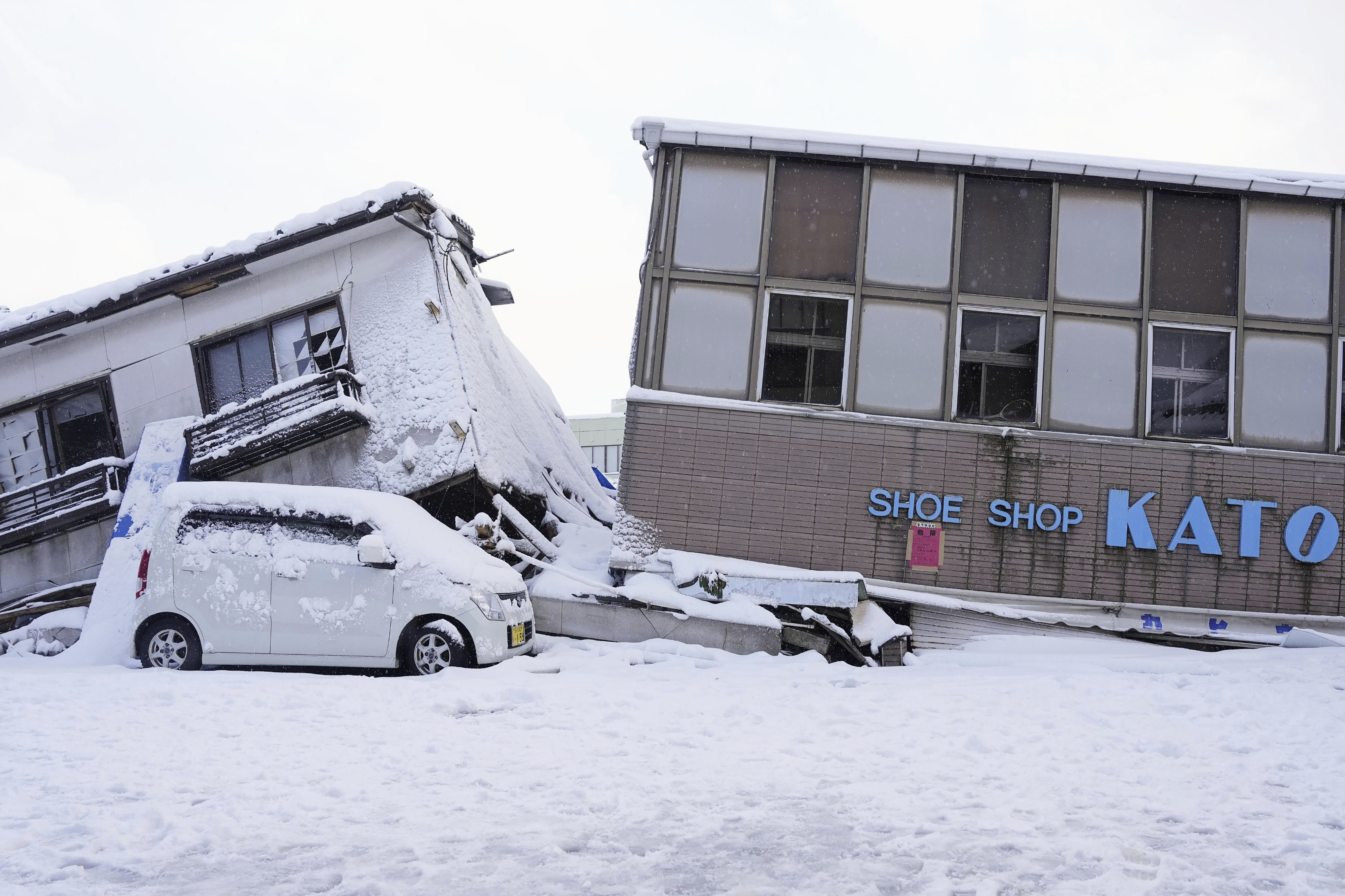Fallen buildings are snow-covered in Anamizi, Ishikawa prefecture, Monday, Jan. 8, 2024. Rescue teams worked through snow to deliver supplies to isolated hamlets Monday, a week after a powerful earthquake hit western Japan. (Kyodo News via AP)